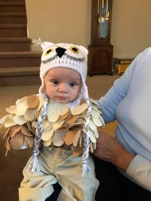 An infant is dressed as an owl, inspired by Harry Potter, for Halloween.