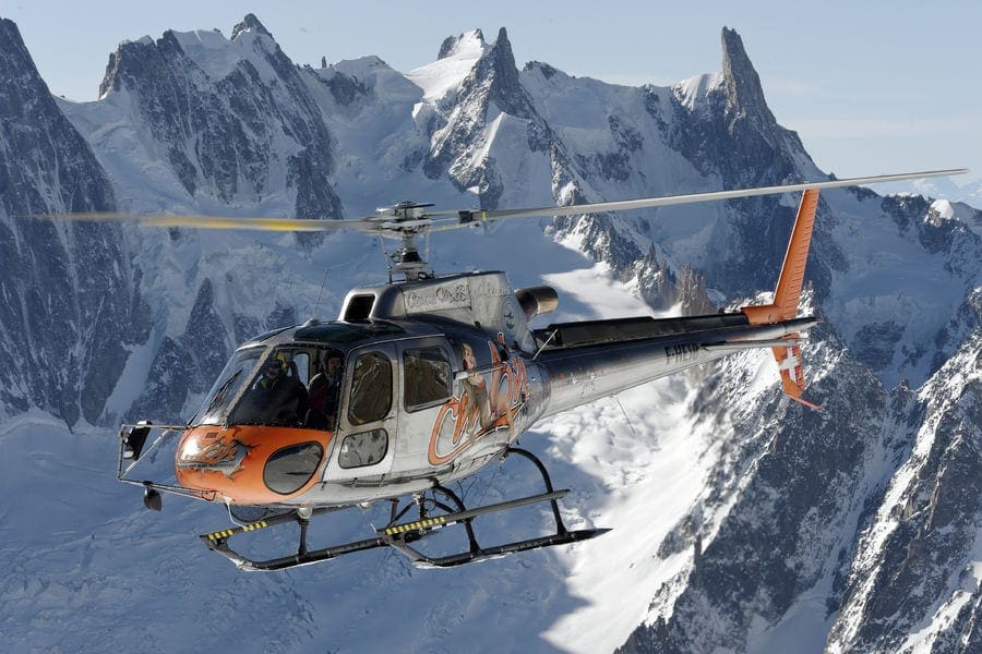 A view of the Mont Blanc helicopter with a snow-capped mountain view in the background. Taking a helicopter ride is , one of the best things to do in Chamonix with kids in Winter.
