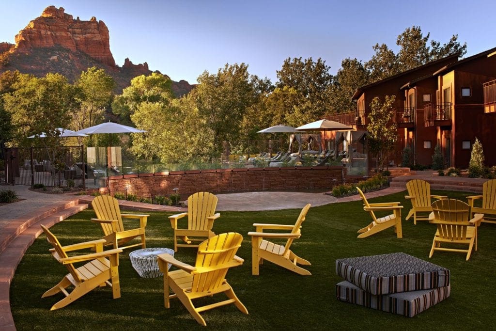 The grounds of Amara Resort and Spa, one of the best hotels in Sedona for kids. Featuring their iconic yellow adirondack chairs, stunning grounds, and the infamous red rocks in the background.
