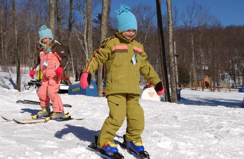 Two kids practice skiing at Skytop Lodge, one of the best family resorts near NYC for a winter getaway.