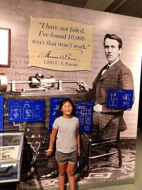 A young girl stands in front of an Edison invention at the Edison Estates in Florida.