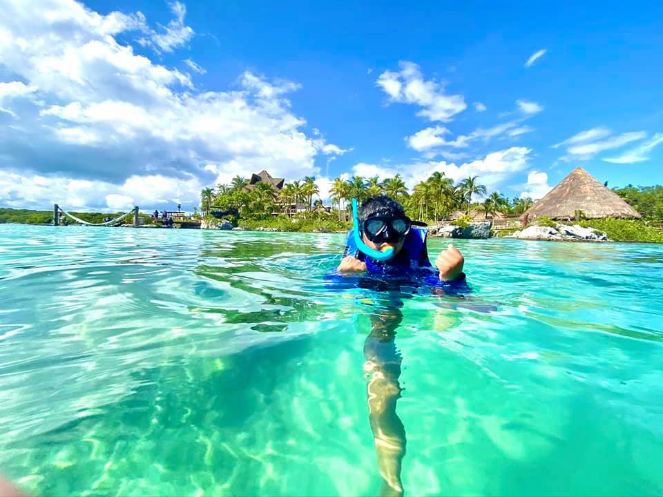 A young boy snorkels in Mexico on a sunny, clear day.