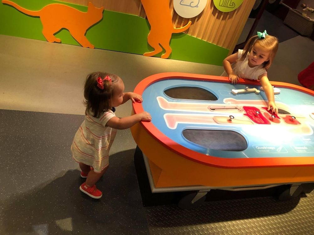 Two small girls play on a large replica of the kid's game 'Operation' at the Miami Children's Museum.