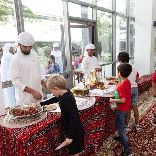Kids approach a table with food at the Sheikh Mohammed bin Rashid Al Maktoum Centre for Cultural Understanding