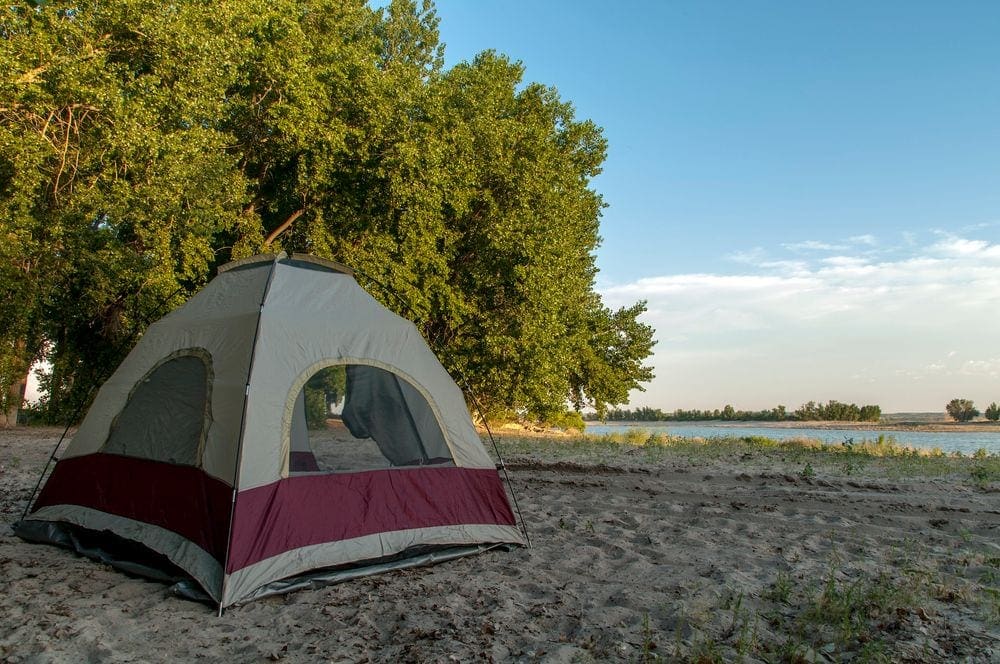 A tent rests on the shores of Lake McConaughy at dusk, one of the best gifts for travelers.