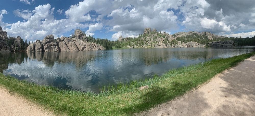 Sylvan Lake, one of the best lakes in the Midwest for families, on a sunny day with the inconic rock formations in the background.