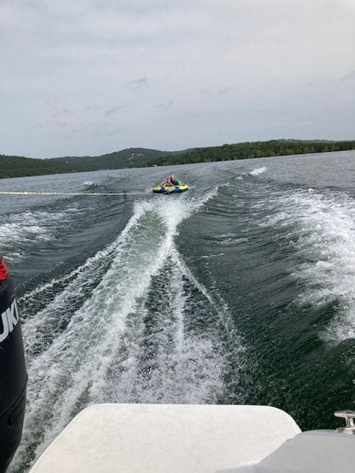 A boat pulls a tube wiht kids on it on Table Rock Lake.