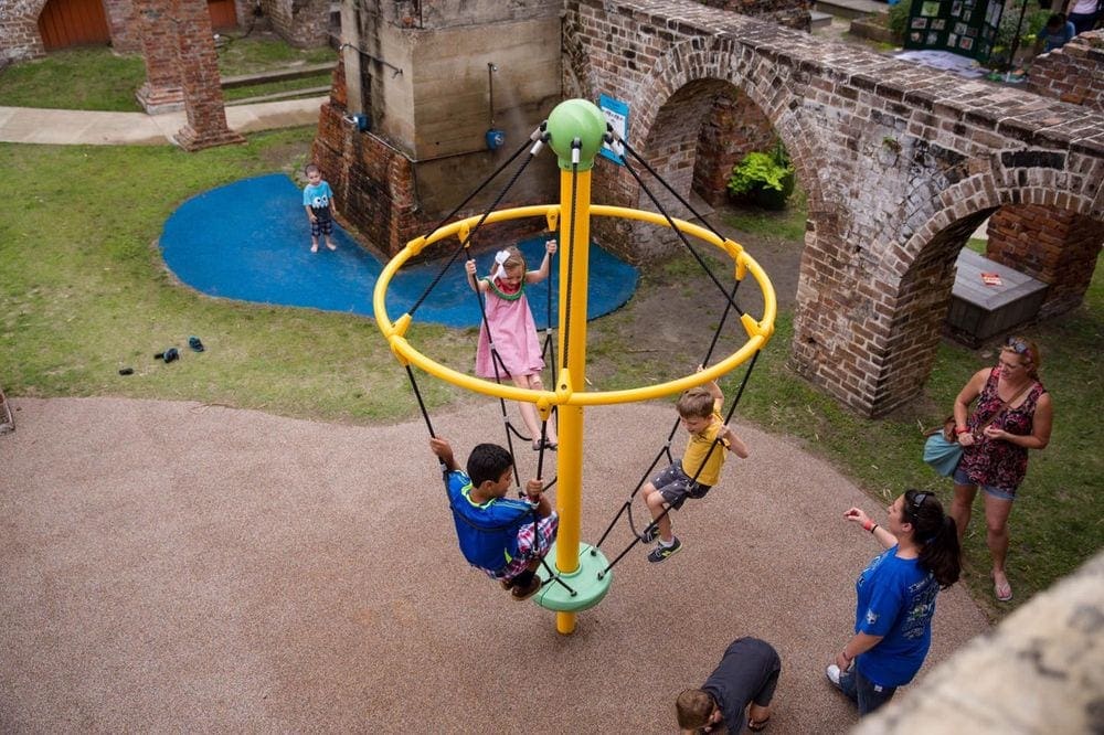 Kids play on playground equipment within Tricentennial Park in Savannah.