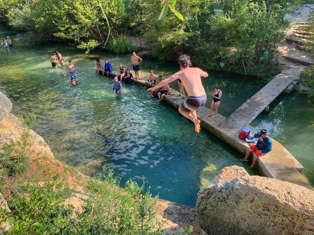 A man jumps into Jacob's Well, a swimming hole near Austin.