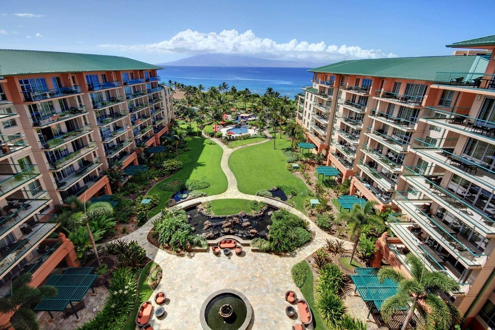 Two resort buildings flank a green space, ideal for kids, at Honua Kai Resort & Spa, one of the best hotels for families in Maui.
