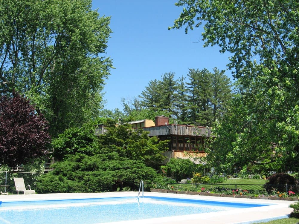 The pool in front of Interlaken Inn, surrounded by trees, one of the most family-friendly hotels in Connecticut.