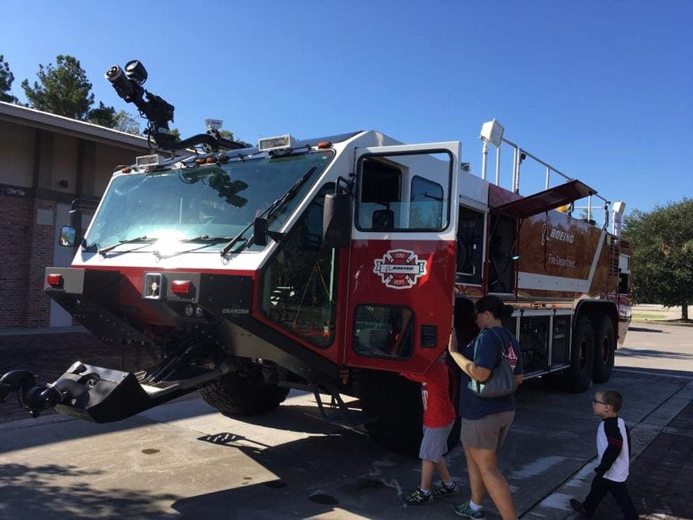A large fire truck sits outside the North Charleston Fire Museum and Educational Center on a sunny day for visitors to tour inside the truck.