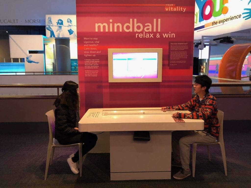 Two kids sit at an exhibit table at the Museum of Science and Industry.