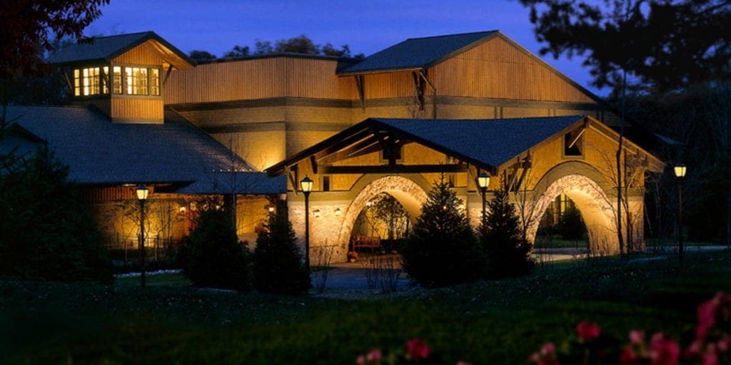 The main building of The Lodge at Woodloch, One of the main buildings at the Winvian Farm, one of the best mom's weekend getaway locations, lit up at night.