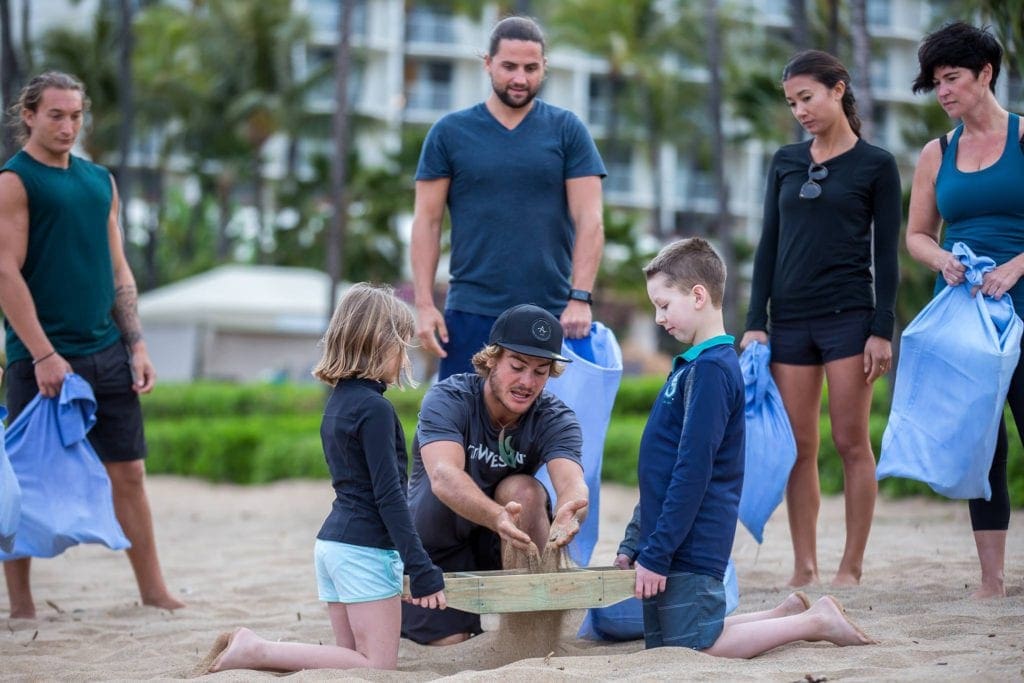 Two kids learn how to play a new beach game from a staff member at the The Westin Maui Resort & Spa, Ka’anapali, one of the best family hotels in Maui.