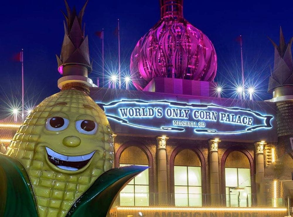 A large plastic ear of corn smiles near the entrance of the World's Only Corn Palace in Mitchell, South Dakota, a great stop for a Midwest road trip with kids.