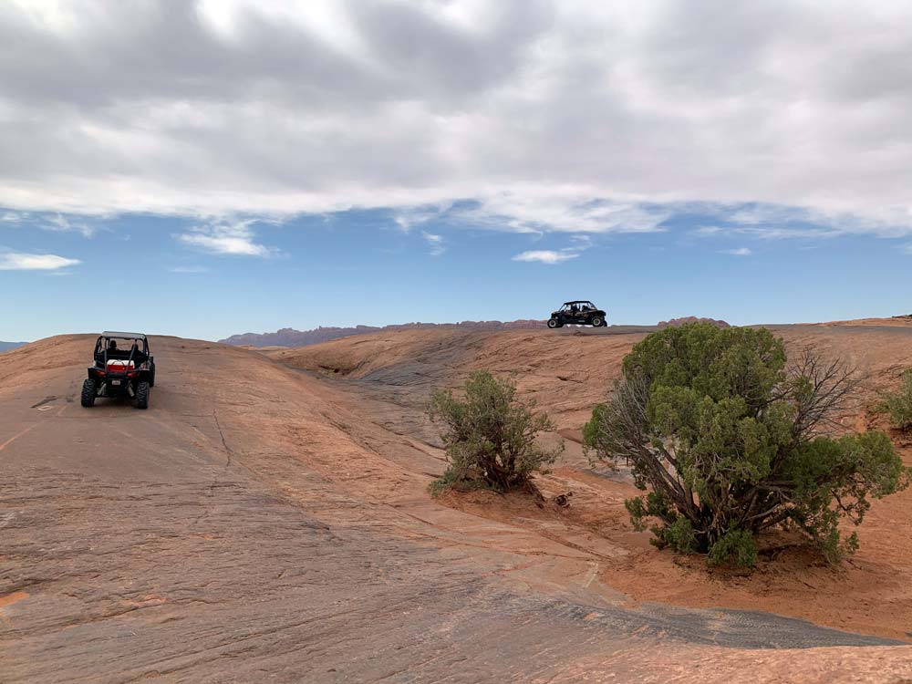 Two 4x4 vehicles roam paths in the Utah.