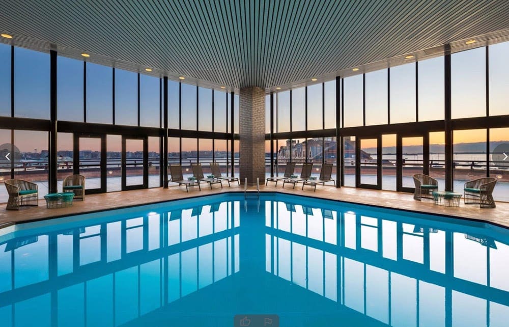 The indoor pool at the Boston Marriott Long Wharf, with floor to ceiling windows surrounding the pool.