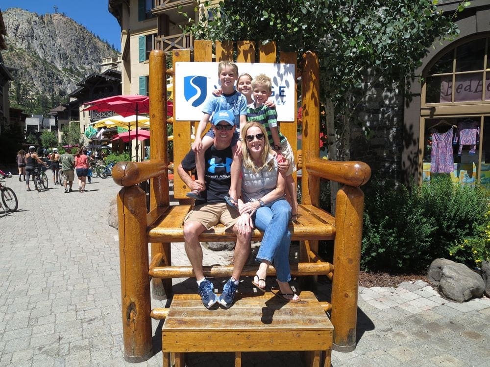 A family of five sits in a huge chair while shopping in Squaw Village.