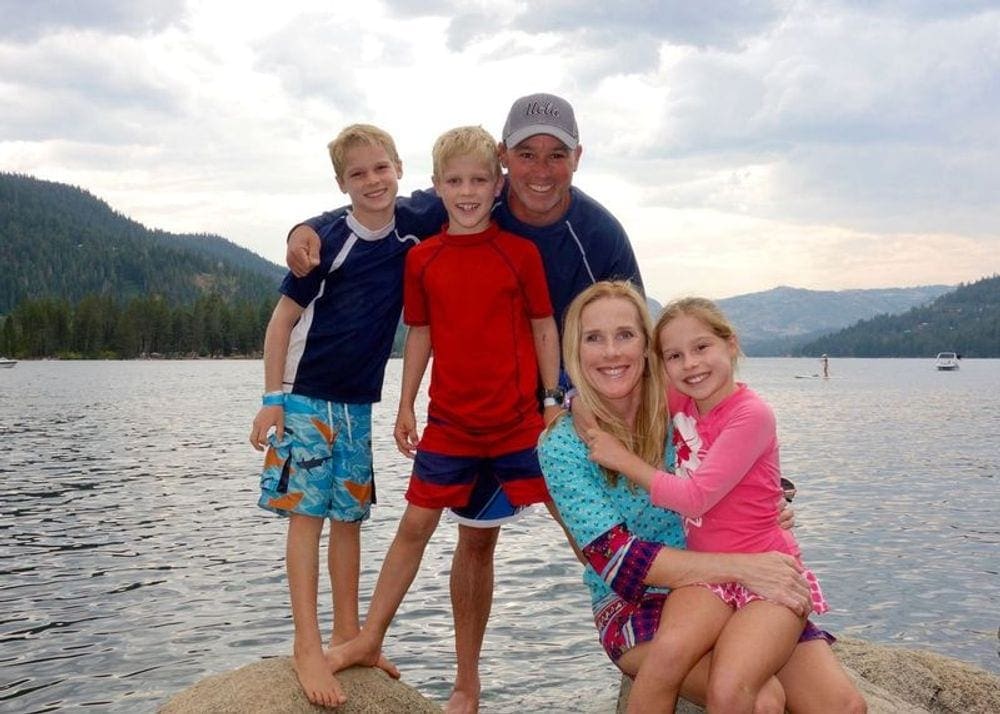 A family of five poses with Lake Tahoe behind them.