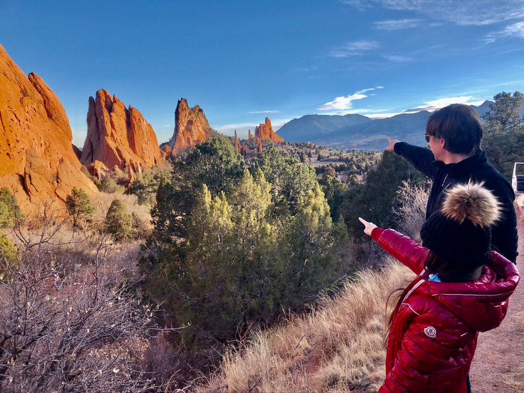 A young girl and her dad point across a valley while exploreing the Garden of the Gods, one of the best things to do in Colorado Springs with kids.