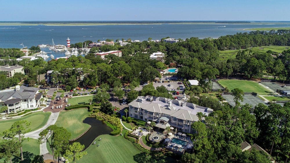 An aerial view of The Inn & Club at Harbour Town - Sea Pines Resort, featuring lush grounds and an ocean view.