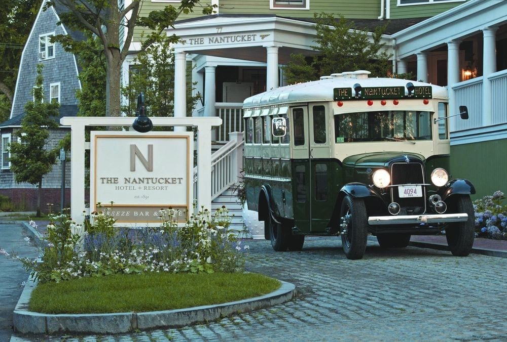 The cobblestone entrance to the The Nantucket Hotel & Resort, featuring the iconic green hotel bus, one of the best places to stay during a family vacation to Nantucket.