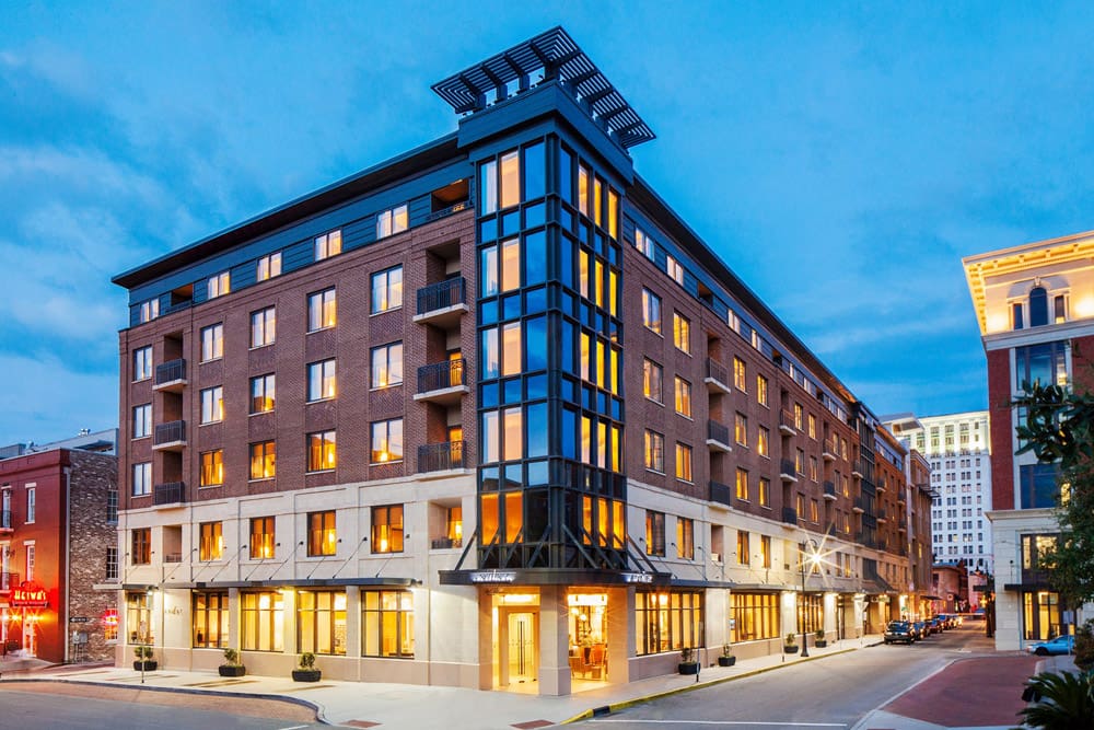 The urban Andaz Savannah – A Concept by Hyatt stands proudly on a street corner, well-lit at night.