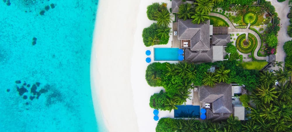 An aerial view of two beach-side bungalows at the Dusit Thani Maldives, one of the best family hotels in the Maldives.