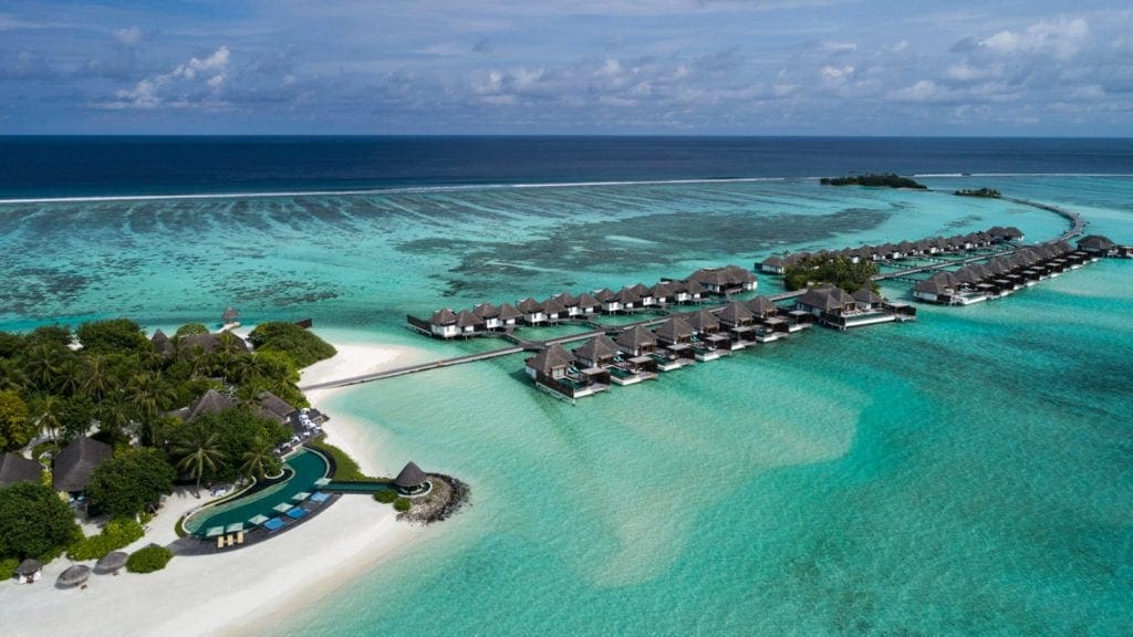 An aerial view of Four Seasons Resort Maldives At Kuda Huraa, featuring several types of options for families to stay on-site.