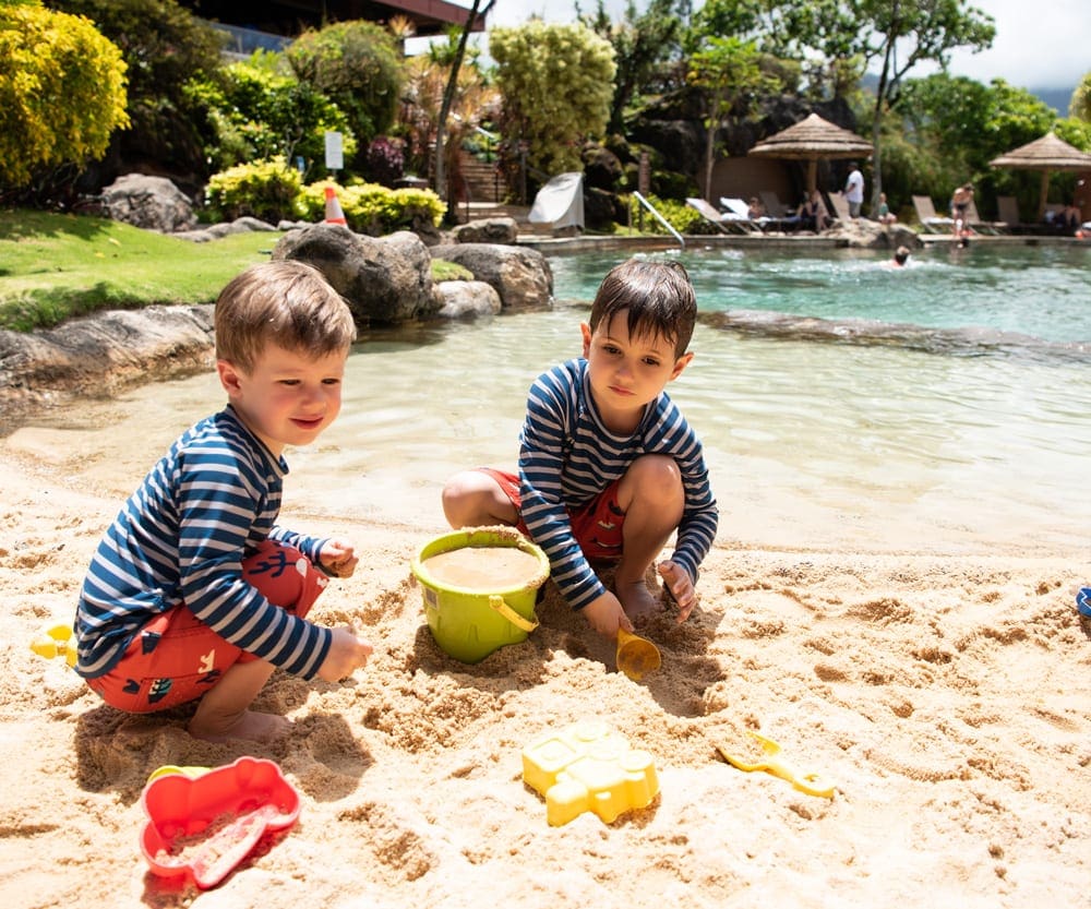 Two boys play on the beach, things to do in Kauai with kids.