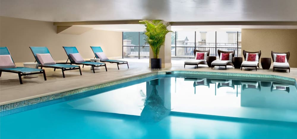 The indoor pool, flanked by loungers, at the Hyatt Regency Savannah, one of the best hotels in Savannah for families.