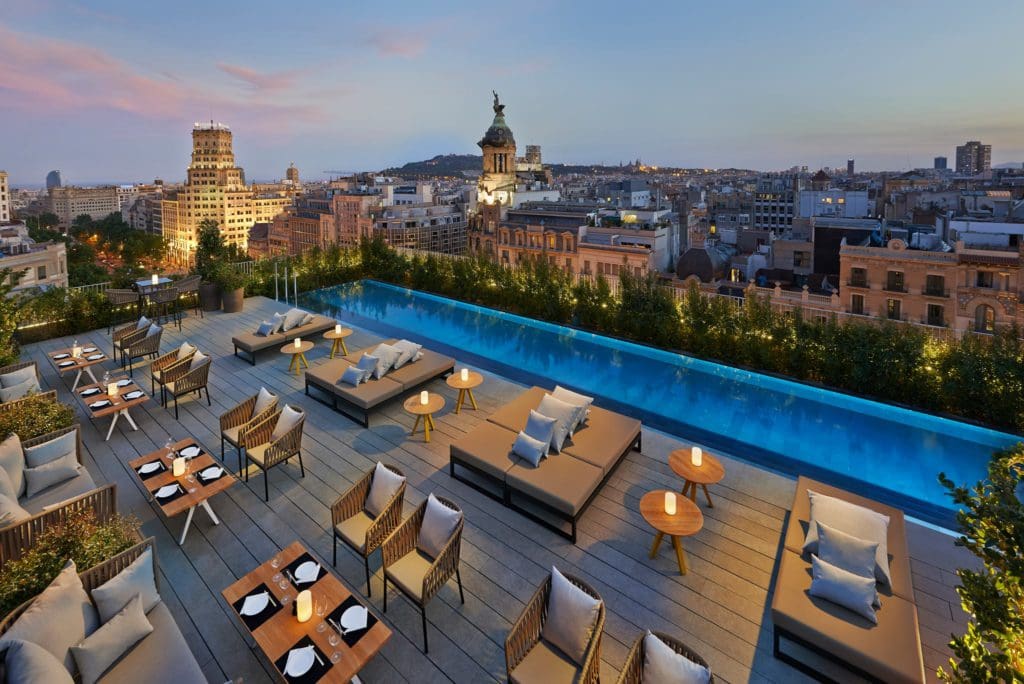 An aerial view of the rooftop pool, loungers, and city view at Mandarin Oriental, Barcelona, one of the best family Barcelona hotels.
