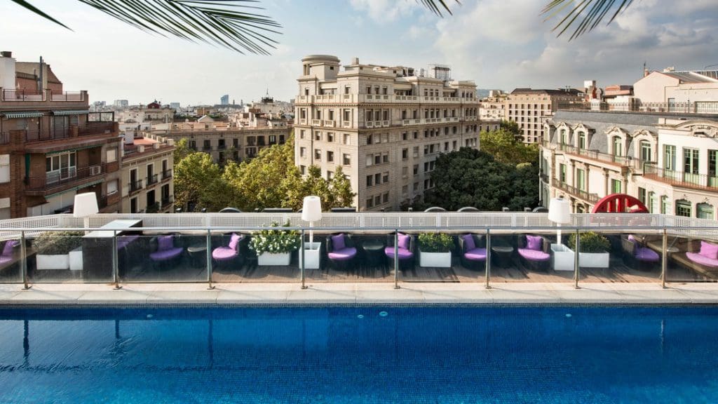 The rooftop pool at the NH Collection Barcelona Pódium on a sunny day, one of the best family Barcelona hotels.