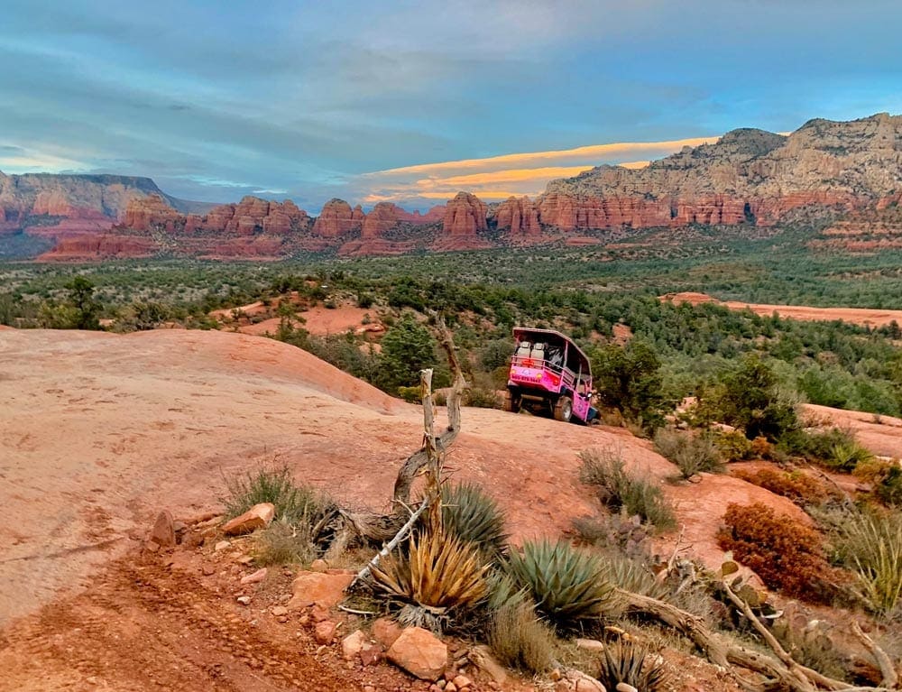 A Pink Jeep Tour traveling through the Sedona landscape. 