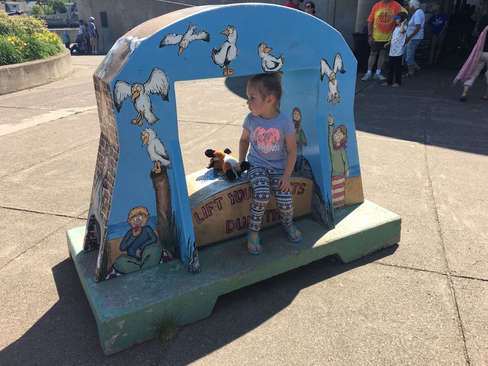 A toddler girl sits inside an artistic replica of the Aerial Lift Bridge in Duluth, Minnesota.