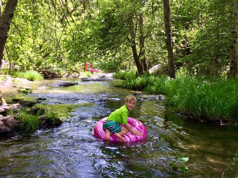 A young boy floats down a river on a pink tube near Arnold, California, one of the best Bay Area weekend getaways with kids.