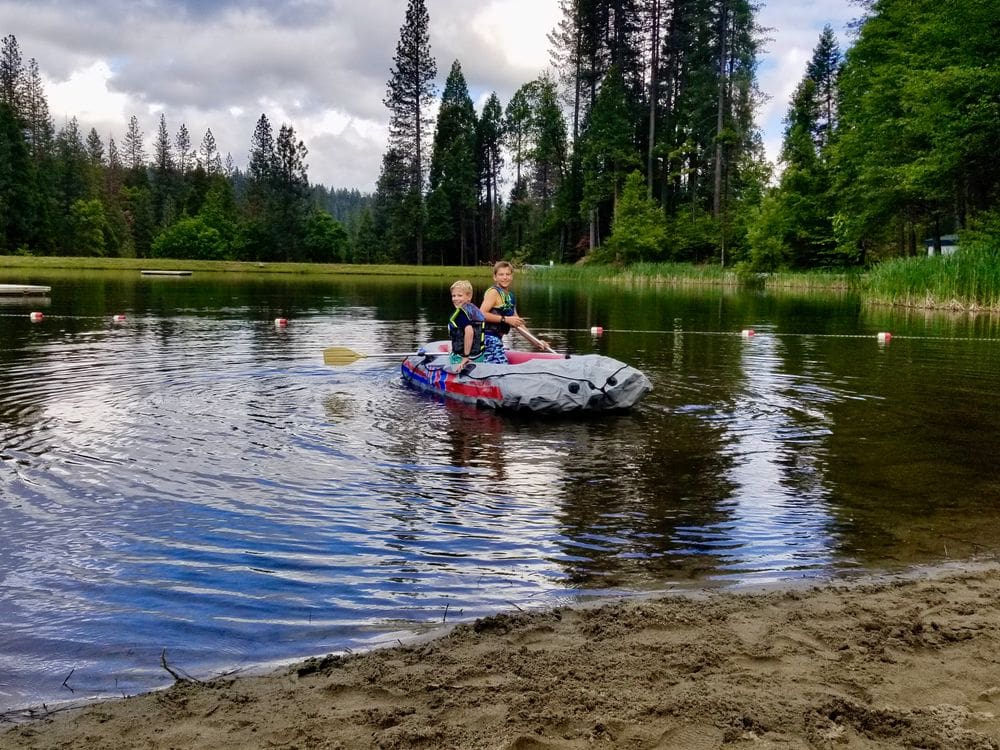 Two kids float along Lake Blue near Arnold, one of the best Bay Area weekend getaways with kids.