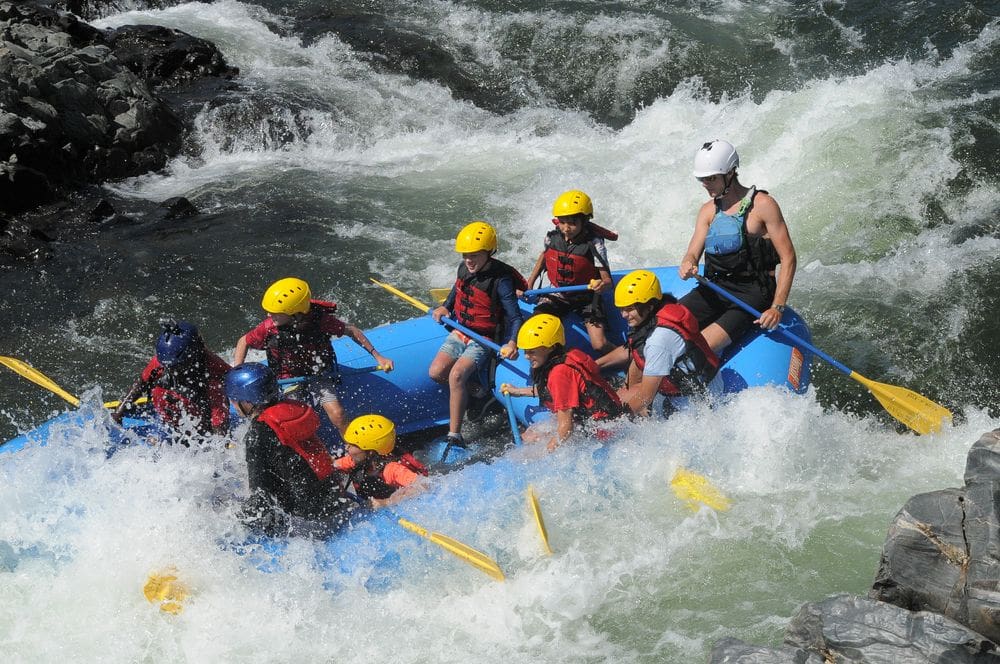 A family rafts down a river near Coloma, one of the best Bay Area weekend getaways with kids.