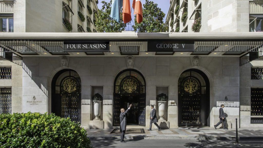 A hotel member flags a taxi outside the entrance of the Four Seasons Hotel George V, Paris .