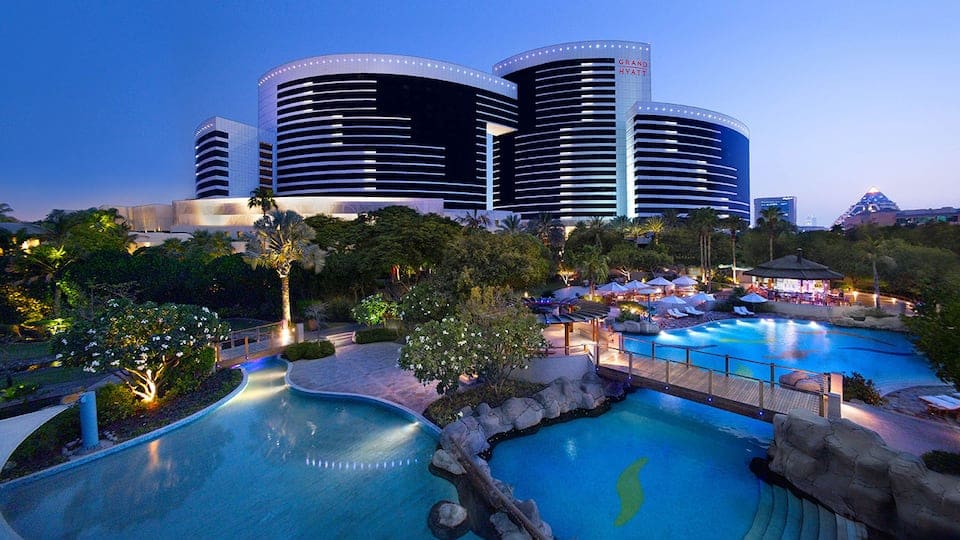 A view of the Grand Hyatt Hotel and Residences Dubai, featuring its many pools at night.
