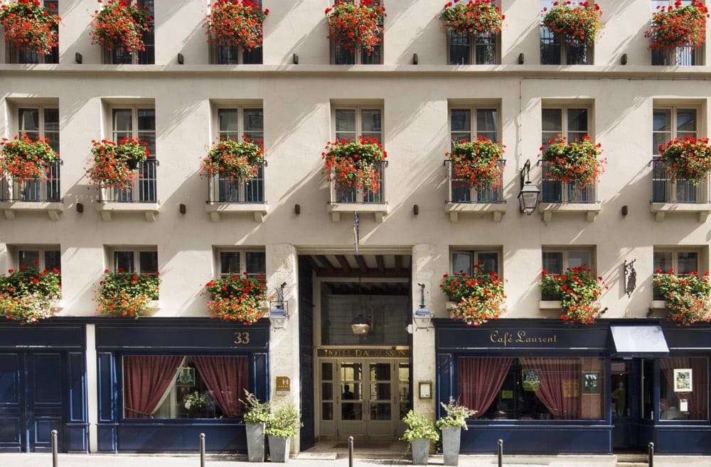 The entrance to the Hôtel d’Aubusson. A large flower basket hangs in each balcony shown.