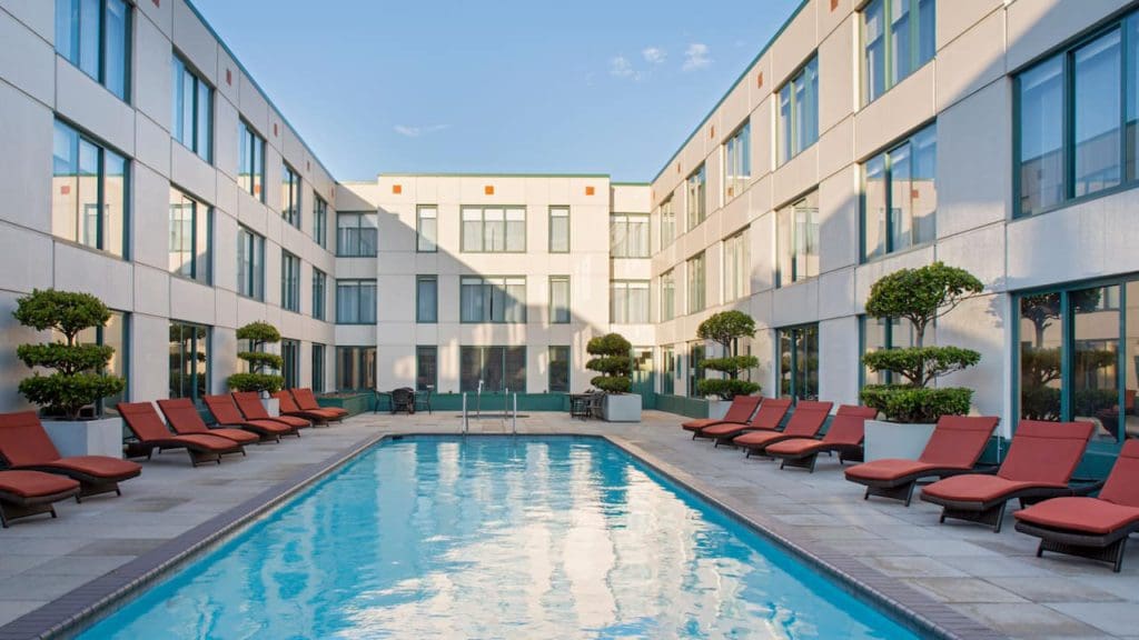 The outdoor pool, flanked by red poolside loungers, at the Hyatt Centric Fisherman’s Wharf San Francisco.