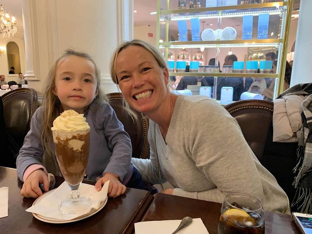 A mom and her daughter indulge in a large chocolate confection at Laduree, one of the best dessert destinations in Paris for families.