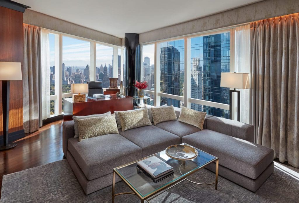 Inside one of the well-furnished suites at the The Mandarin Oriental, New York, with skyline views through the windows.
