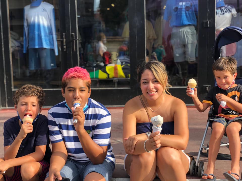 Four kids sitting on the curb enjoy an ice cream cone in Provincetown.