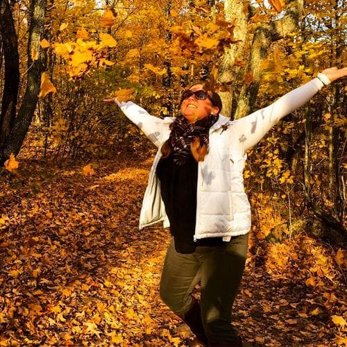 A woman dances in fallen autumn leaves along the North Shore of Minnesota.
