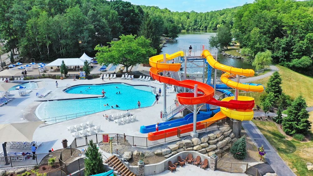 An aerial view of the outdoor water park, featuring large yellow, orange, and blue slides at the Big Splash Indoor Water Park and Boulder Bay Outdoor Aquatic Adventure at Rocking Horse Ranch Resort.