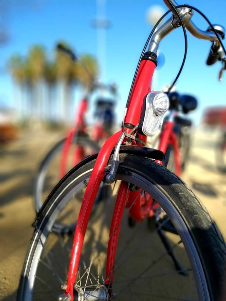 A closed up of a bright red biked, including the upper wheel and handle bars.