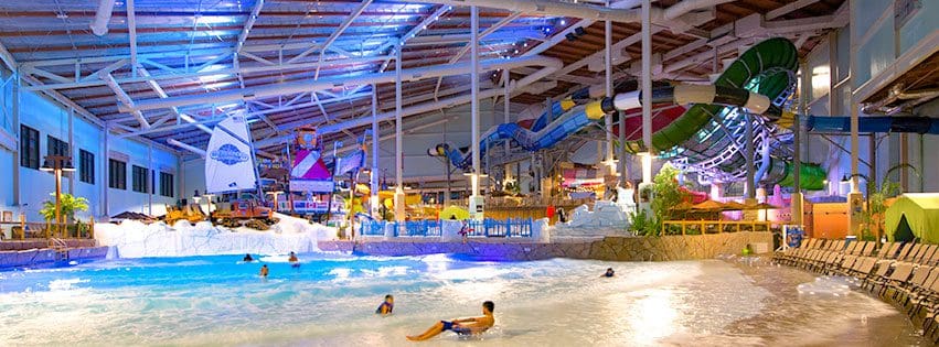 Inside the indoor water park at Camelback Resort and Water Park at night, featuring fun lights and several swimmers.